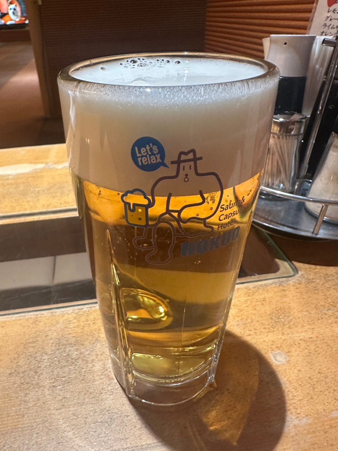 北欧のキャラクターとLet's relaxの文字が入ったグラスに注がれたビール