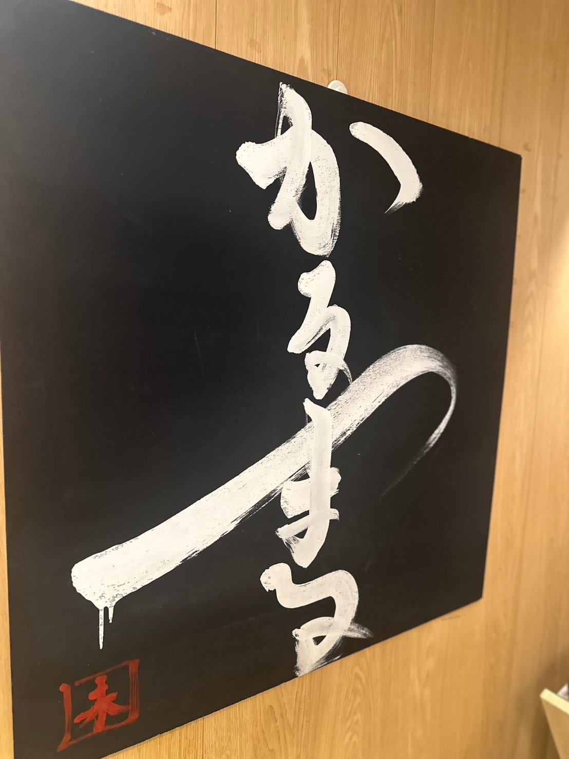 かるまるの木の壁に飾られたかるまるの書