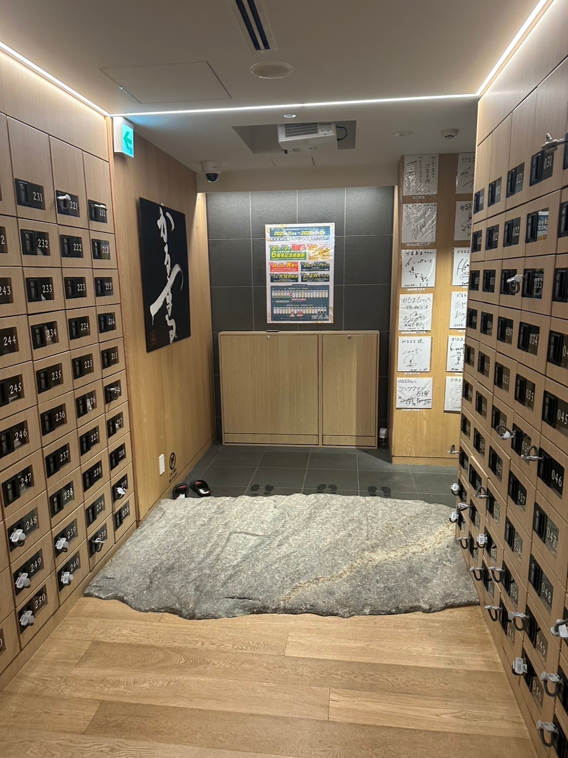 木目の靴箱と足元の大きな石が印象的なかるまるの入口